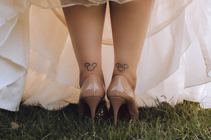 Legs Of A Bride With Micky And Minnie Tattoos On Ankles