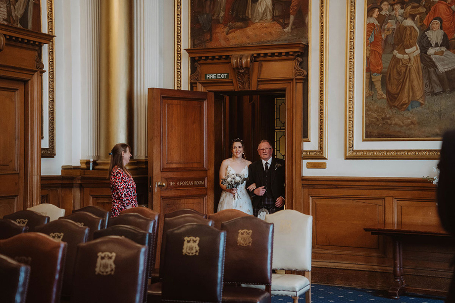 Bride and her father enter ceremony room