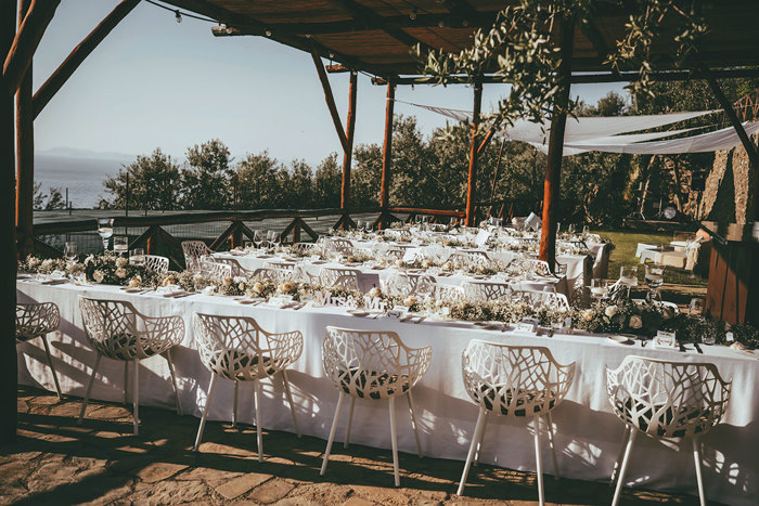 A wedding ceremony set up with white chairs and a table at Art Hotel Villa Fiorella Sorrento