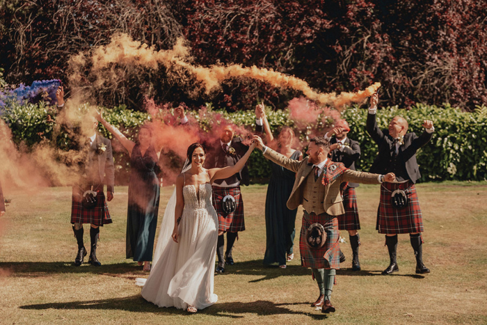Bridal party hold brightly coloured flares