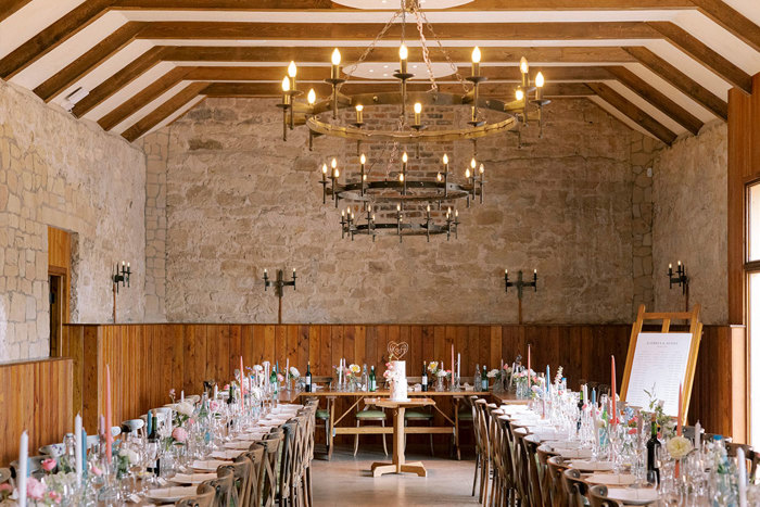 a barn set with long tables for dinner
