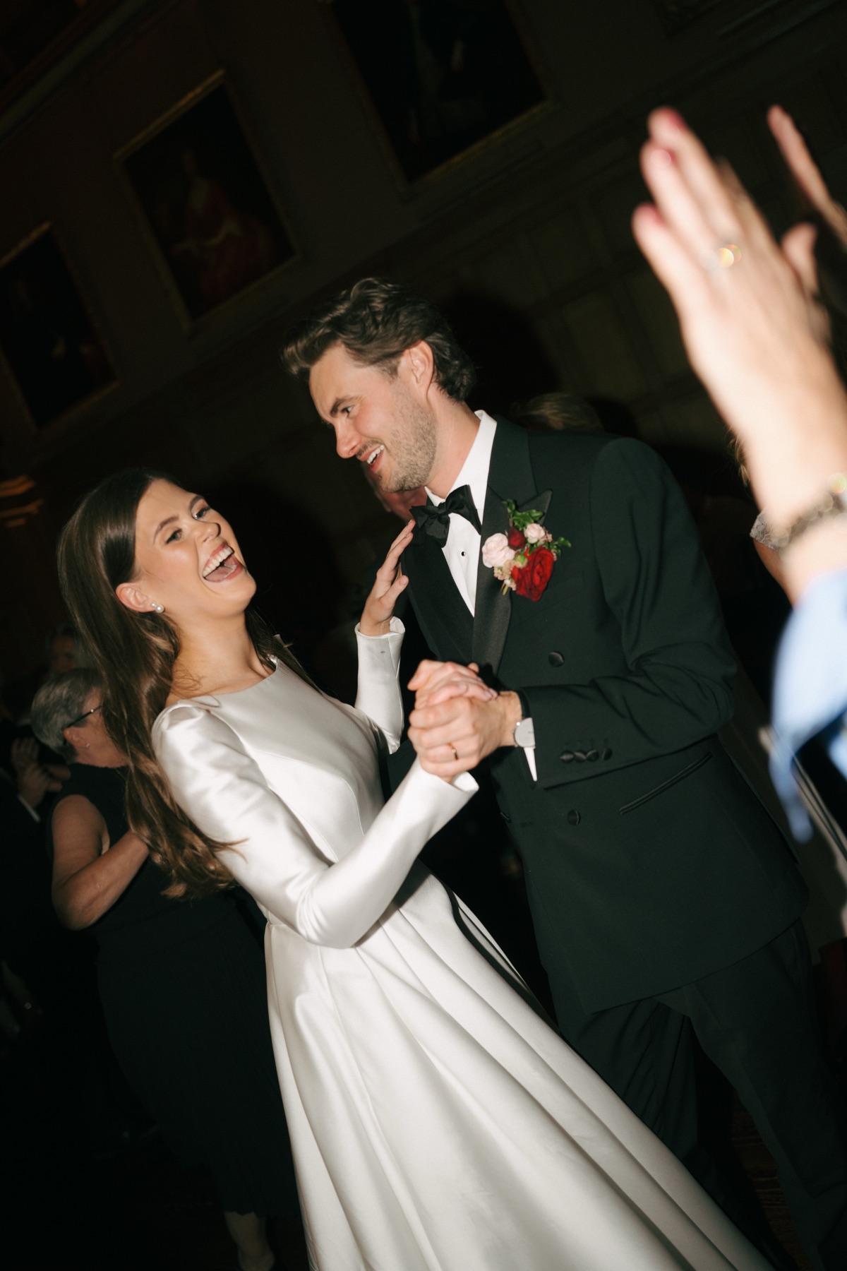 Nicole and Ryan laugh together during their first dance at Barnbougle Castle, with Nicole wearing her long-sleeved Suzanne Neville wedding dress.