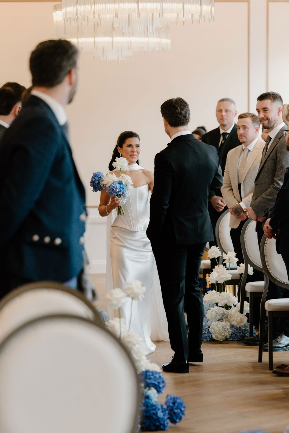 Groom meeting the bride partway down the aisle during their wedding ceremony at The Exchange in Glasgow.