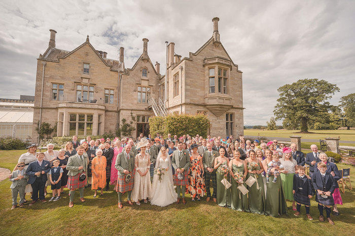 A large group of people standing outside a country house 