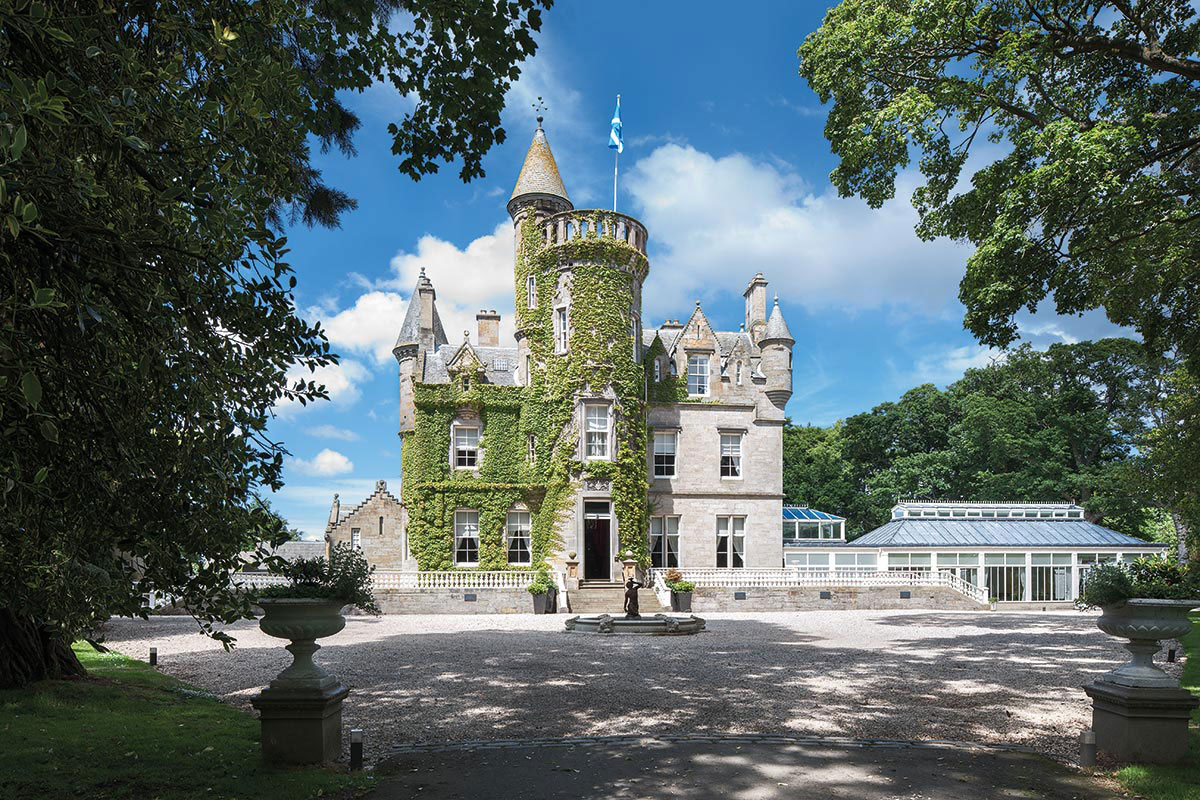 Exterior of Carlowrie Castle wedding venue near Edinburgh, with ivy-covered stonework, turrets and landscaped grounds