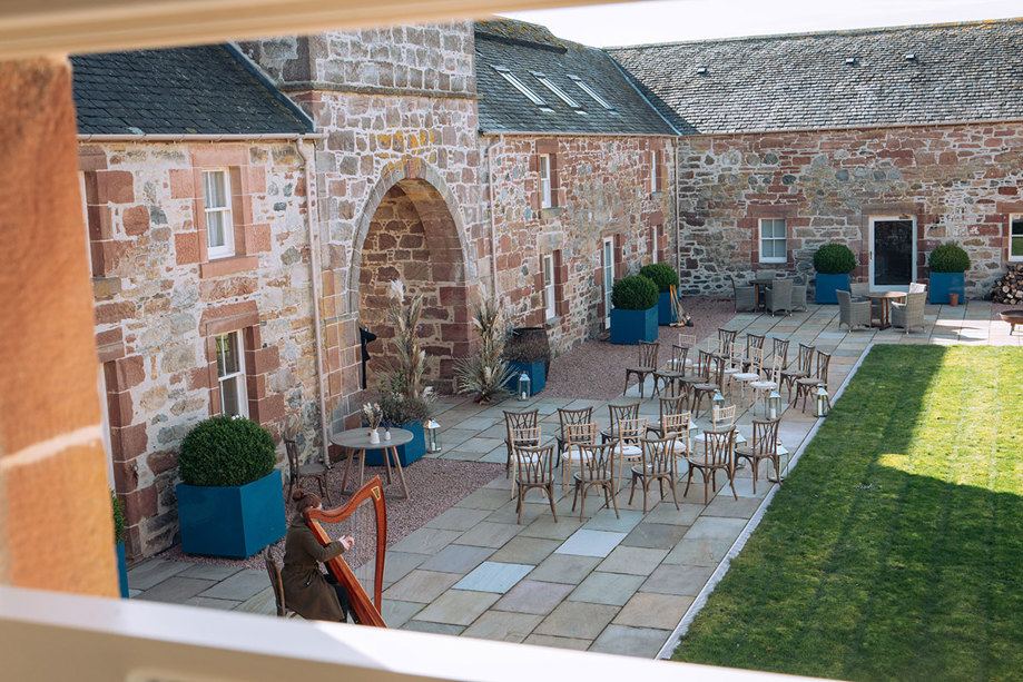 Ceremony in Newhall Mains courtyard with harpist playing