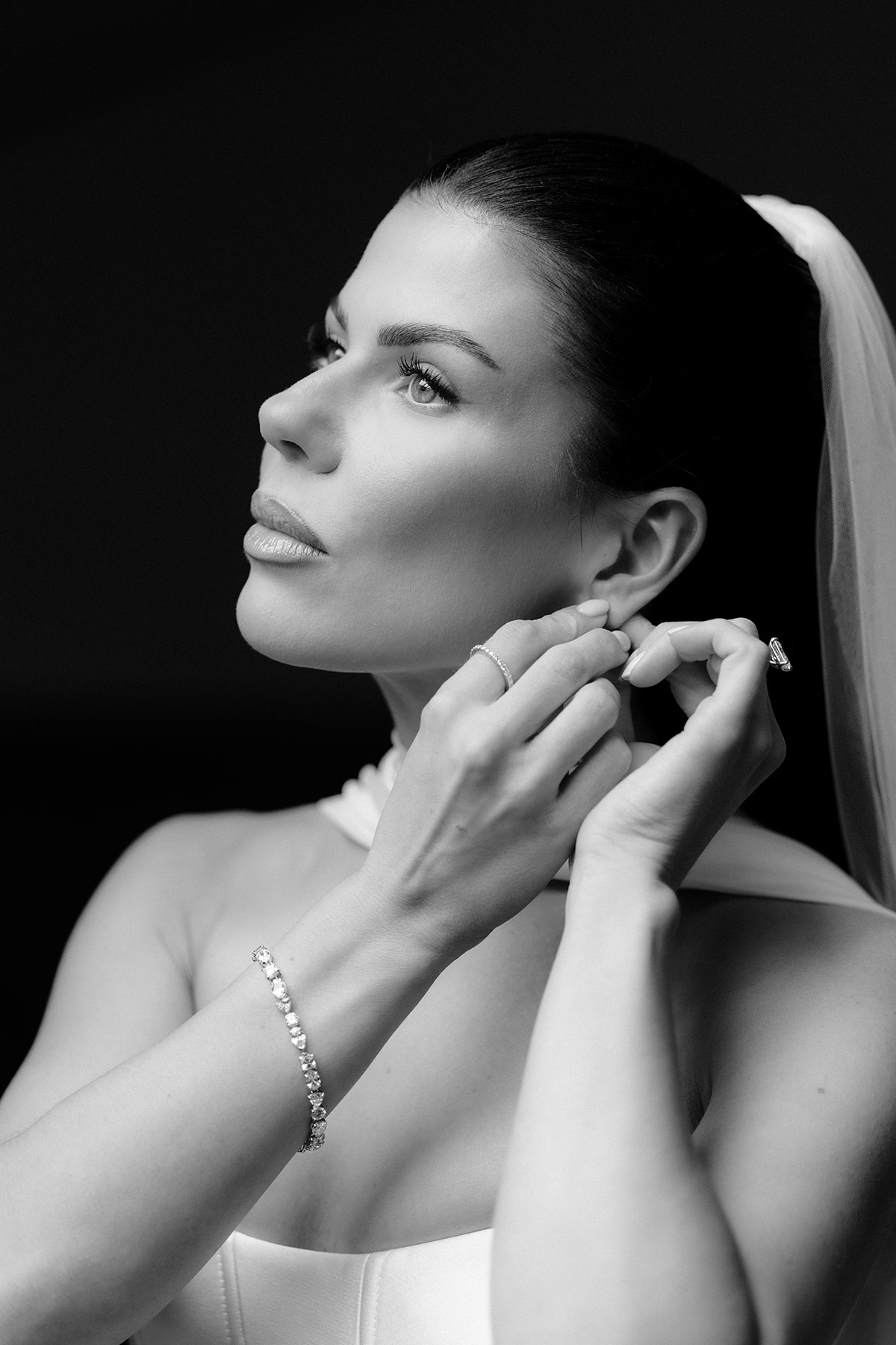 Bride adjusting her earring during bridal prep at The Exchange Glasgow, black and white close-up portrait