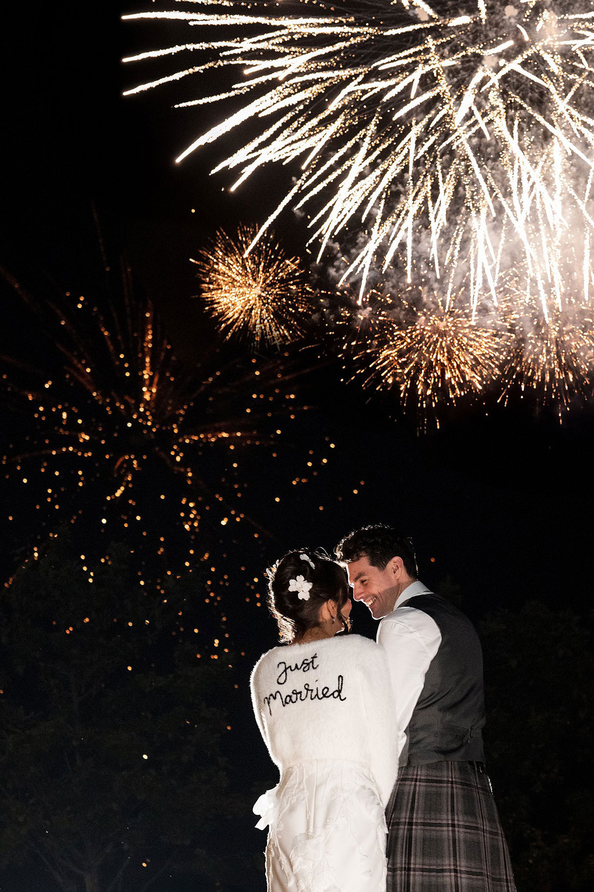 Newlyweds watching fireworks together at night during Old Course Hotel wedding celebration in St Andrews.
