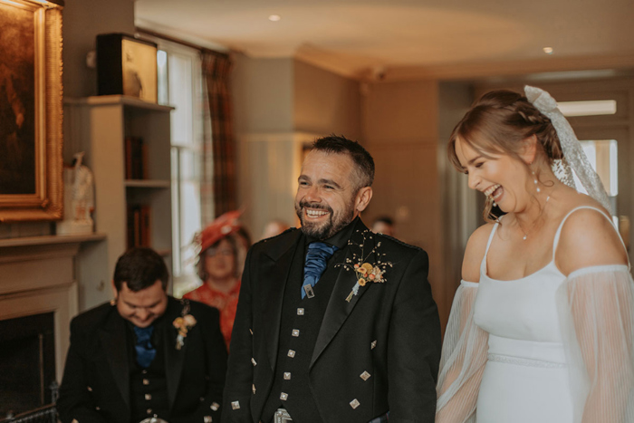Bride and groom laugh during their wedding ceremony
