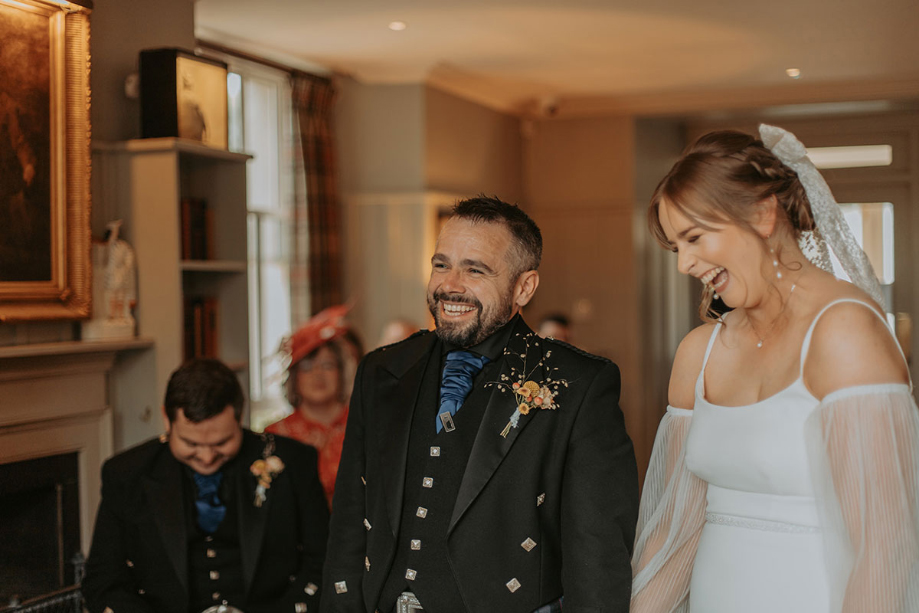 Bride and groom laugh during their wedding ceremony