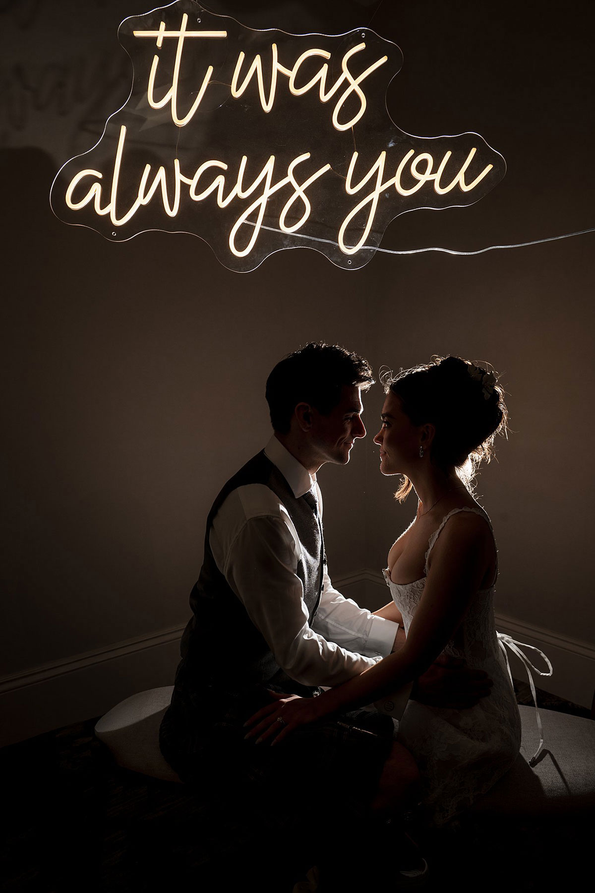 Romantic silhouette portrait of bride and groom beneath glowing “it was always you” neon sign at Old Course Hotel wedding.