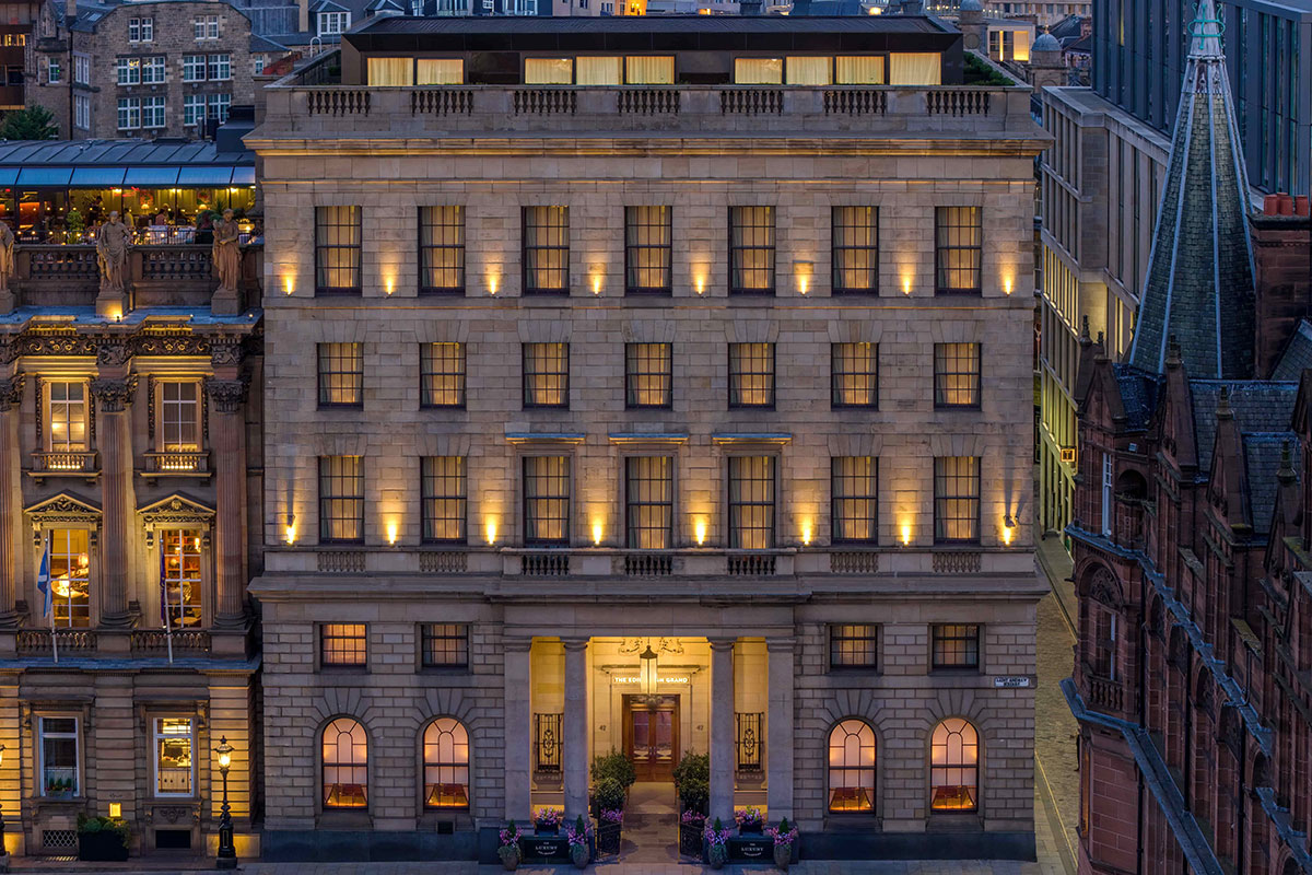 the exterior of a multi-story city hotel lit up at night