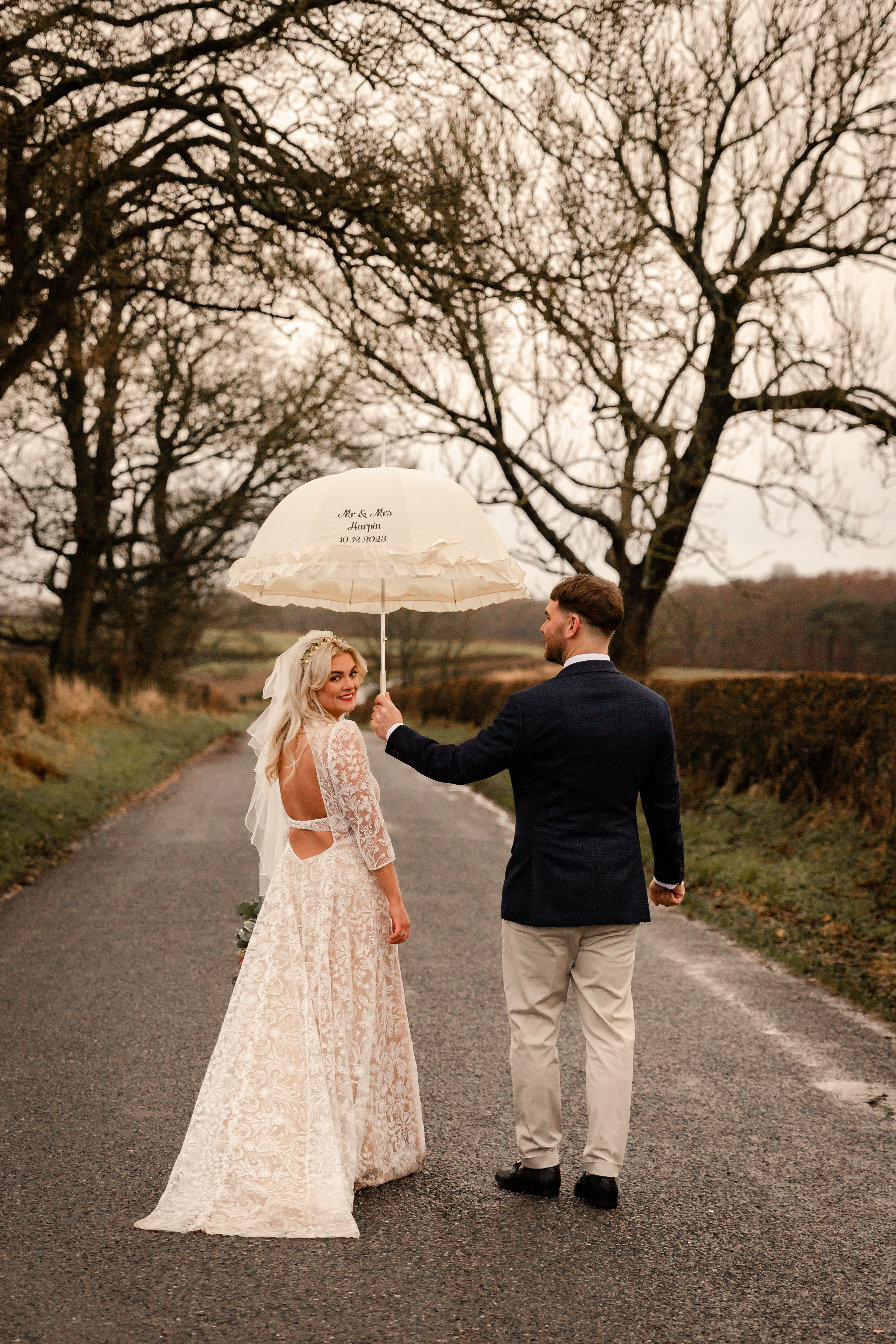 bride facing camera while groom holds umbrella at Gretna Green