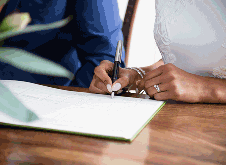 bride and groom sign marriage license after getting married