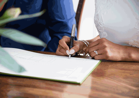 bride and groom sign marriage license after getting married