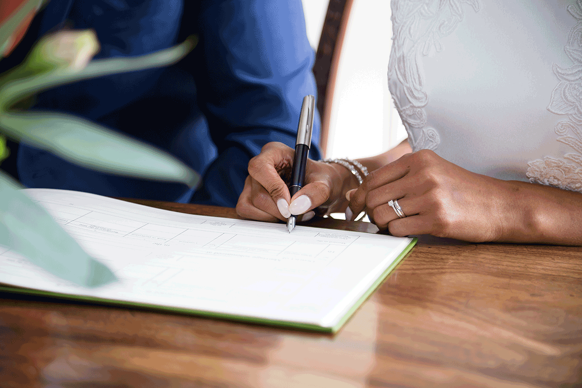 bride and groom sign marriage license after getting married