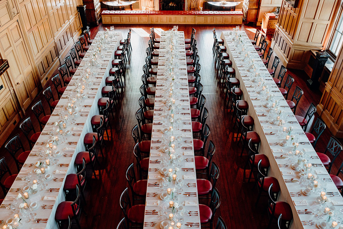 Long wedding breakfast tables set up inside a wood-panelled dining room at Barnbougle Castle