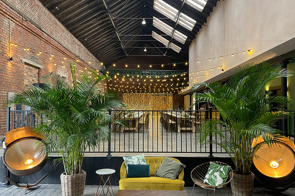 balcony at Engine Works with a yellow velvet couch and plants