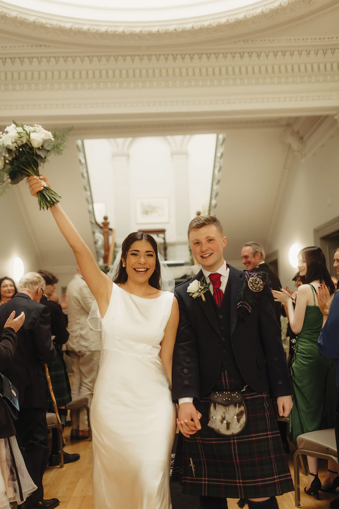 bride and groom cheer after wedding ceremony at kilmardinny house in bearsden