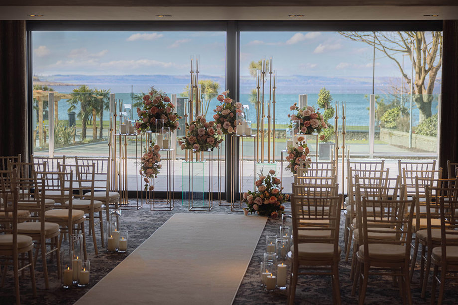 large windows behind ceremony set-up reveal ocean view