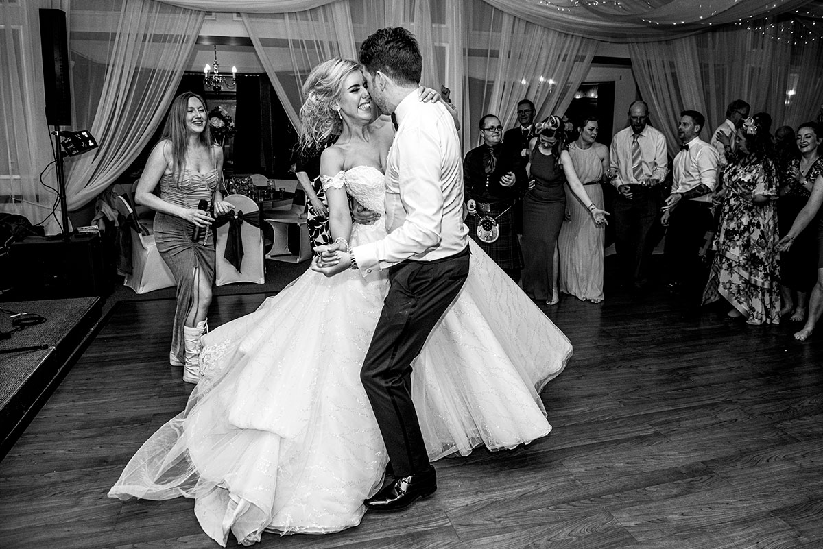 A Black And White Image Of A Bride And Groom Dancing At The Weigh Inn