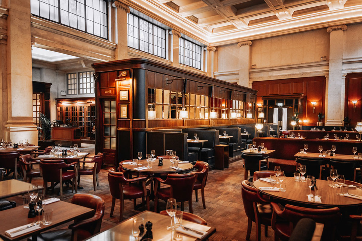 Interior of Hawksmoor Edinburgh with leather booths, wooden tables and warm lighting
