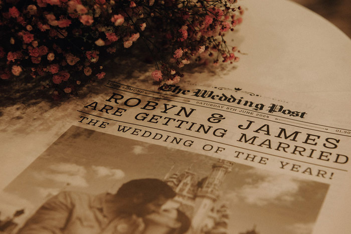 a wedding newspaper on a table with flowers.