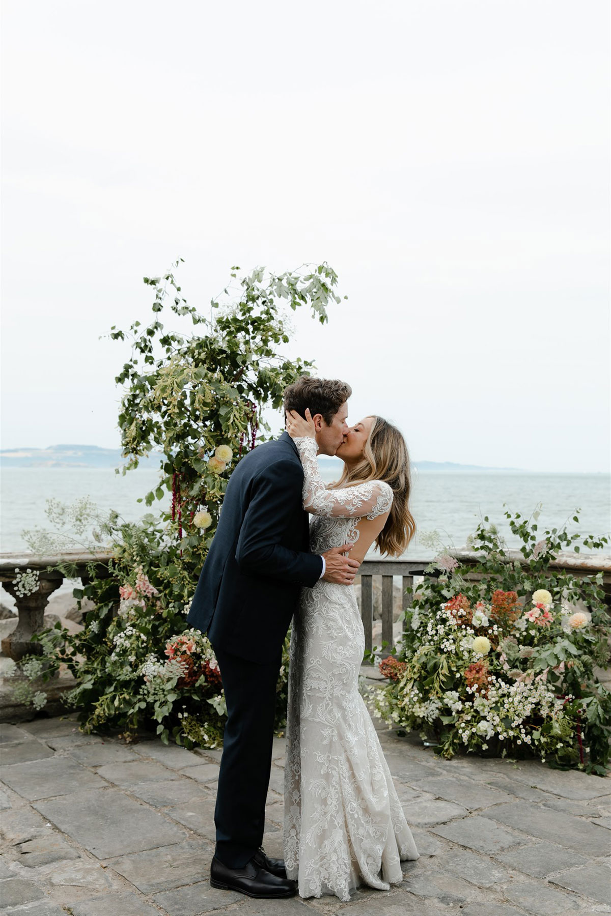 Barnbougle Castle seaside coastal wedding venue outdoor wedding ceremony on terrace with bride and groom kissing