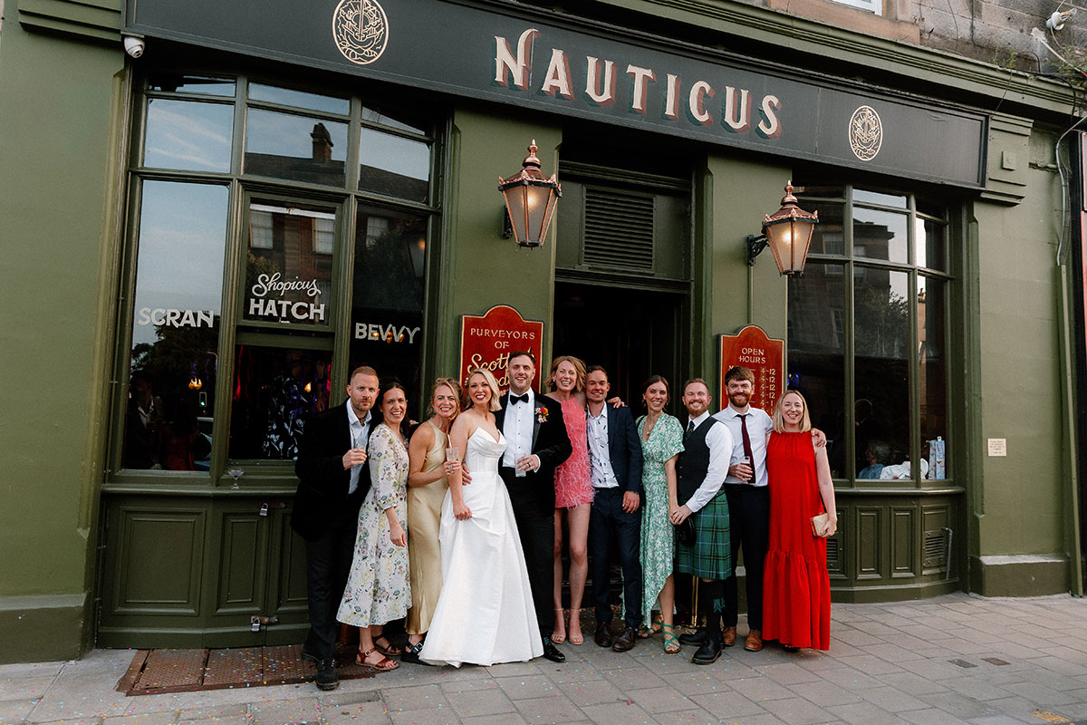 Wedding couple and guests posing outside Nauticus in Leith after their Edinburgh wedding celebration.