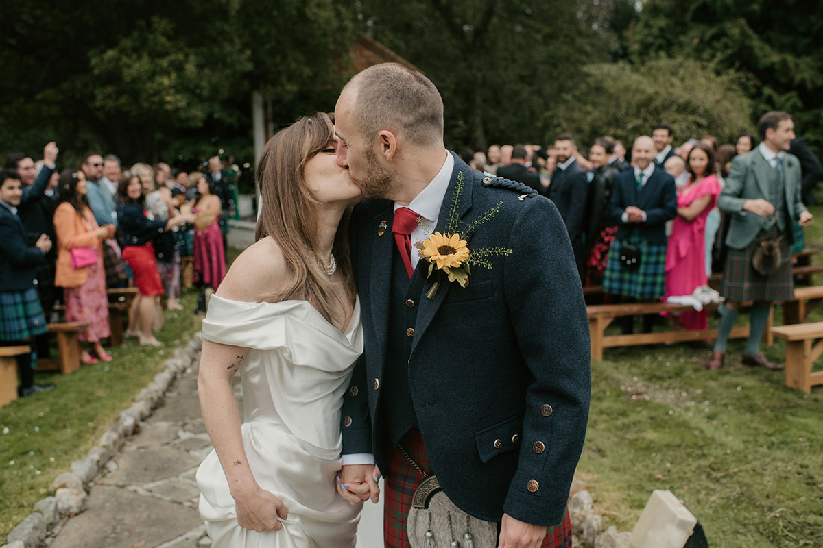 bride and groom kissing after outside ceremony at Achnagairn Castle