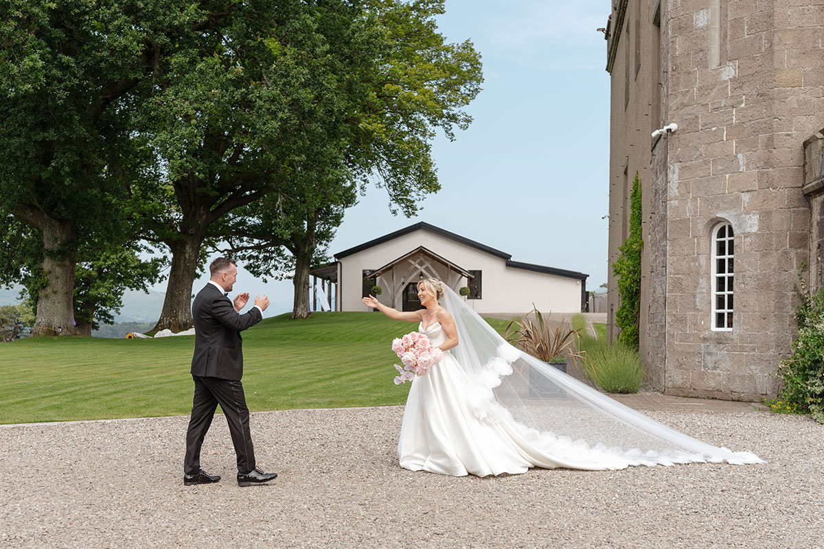 Bride and groom smile during their first look outside Boturich Castle before their Loch Lomond wedding ceremony.
