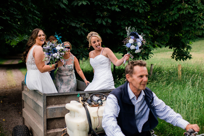 Two brides get a ride on back of quad bike with cart attached 