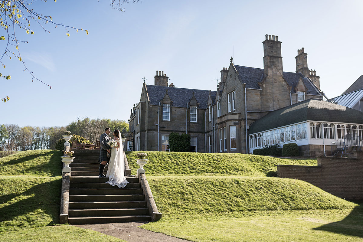 Bride and groom on the garden steps outside Norton House Hotel in Edinburgh during their Scottish wedding day