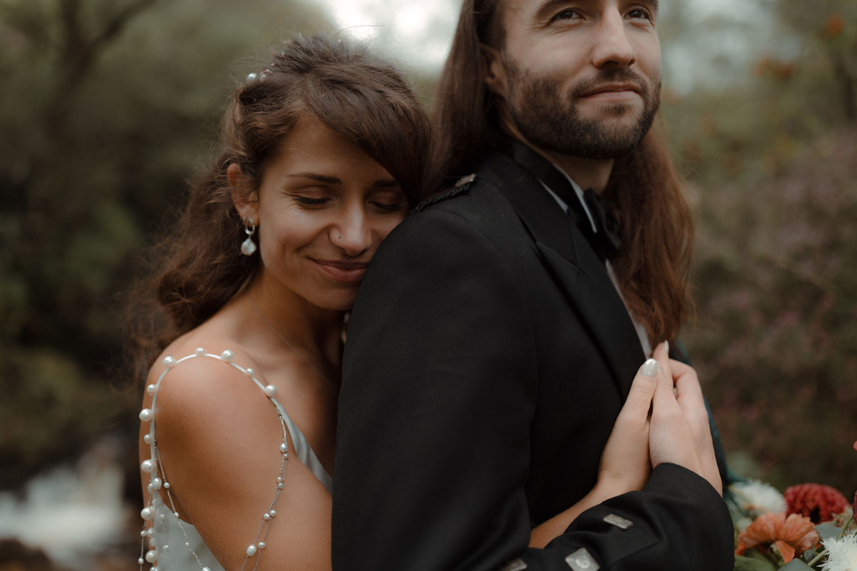 a bride and groom close up portrait by a waterfall at their Carrick Castle Estate wedding