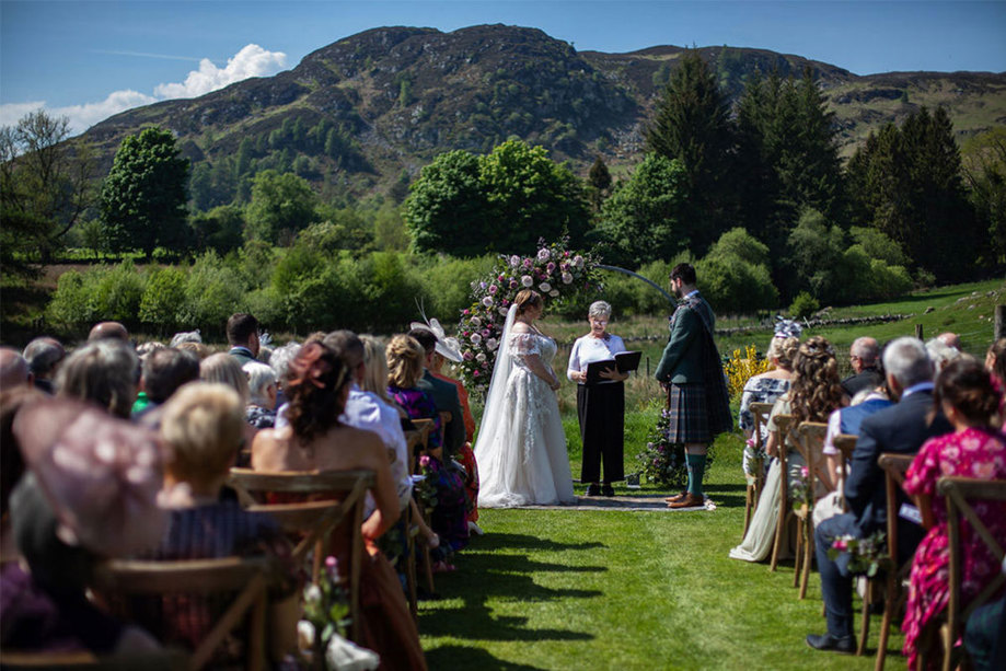 An outdoor wedding ceremony with hills in the background