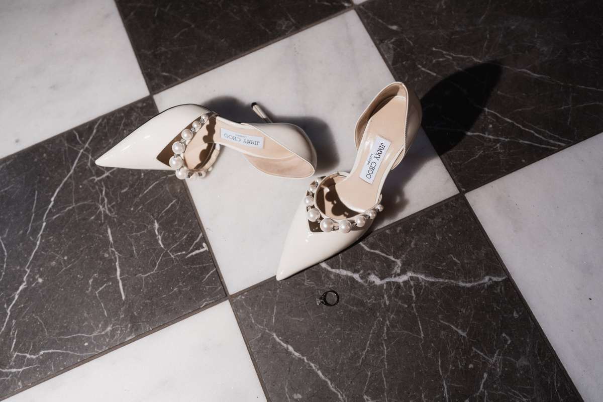 Siân’s ivory pointed Jimmy Choo wedding shoes with pearl straps photographed on a chequered floor at Mar Hall.