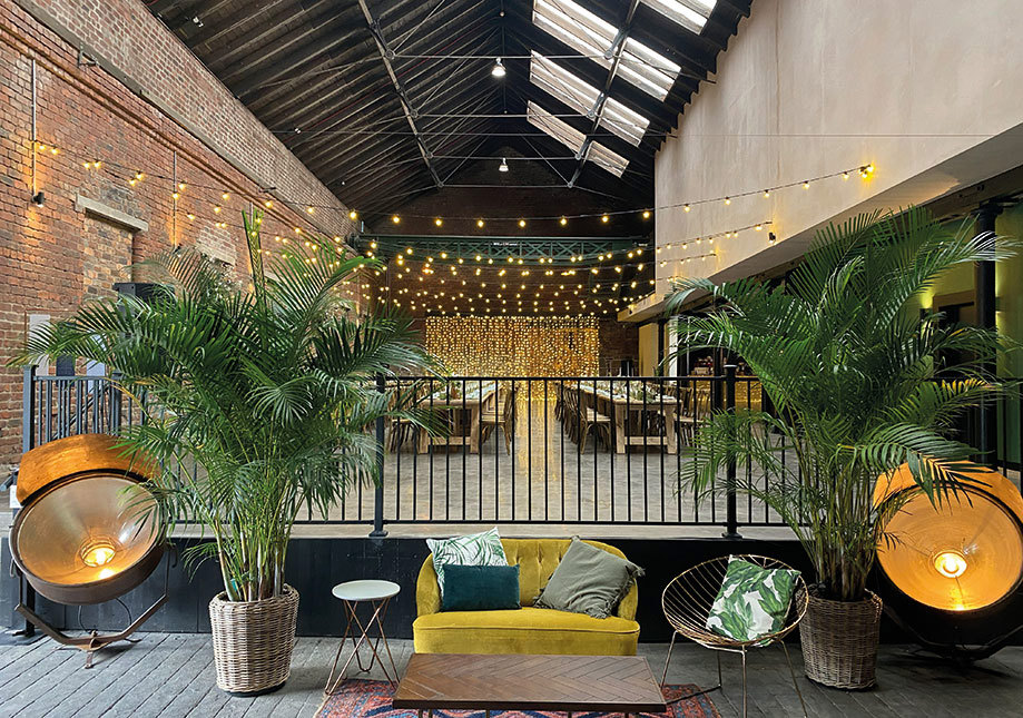 balcony at Engine Works with a yellow velvet couch and plants