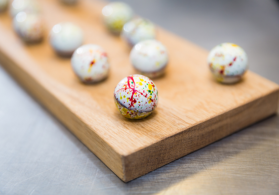 decorated white and coloured chocolates on wooden slab