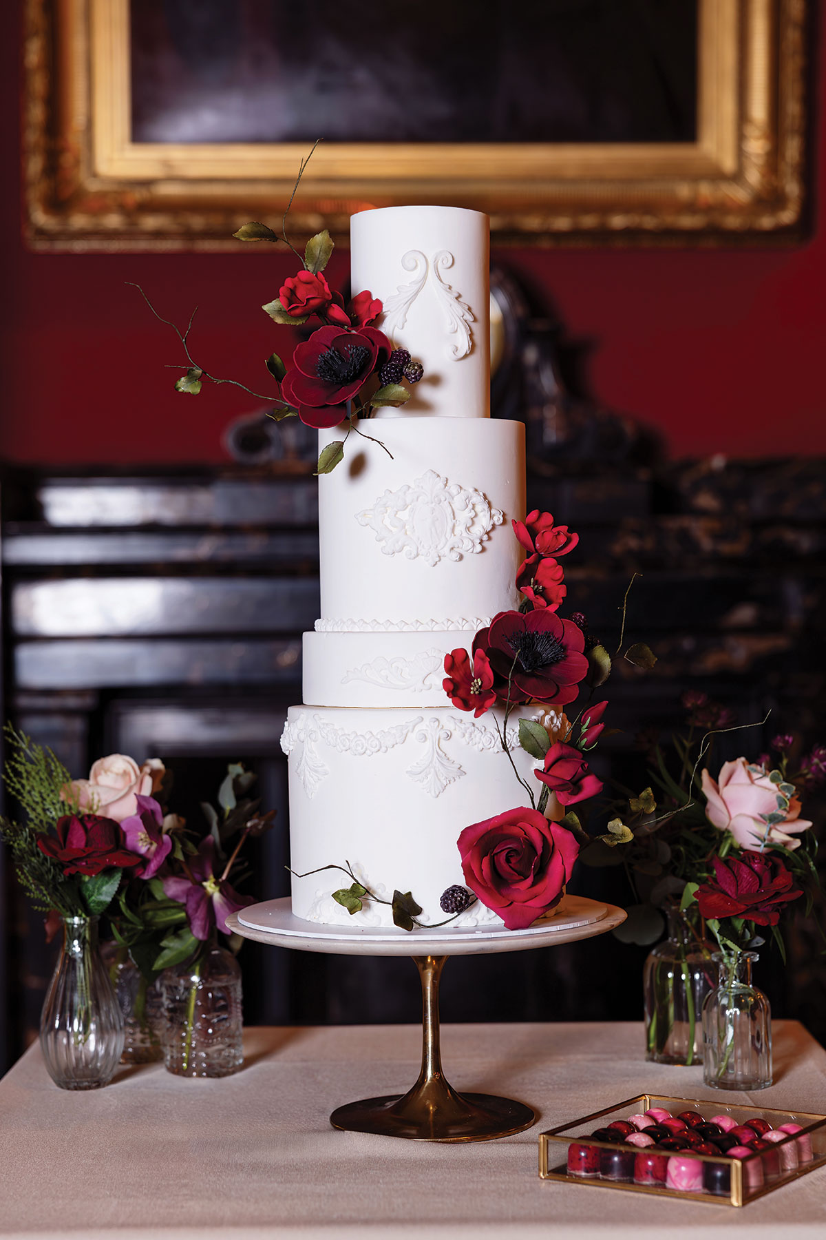 White tiered wedding cake with red sugar flowers and embossed detailing at elegant Scottish wedding venue RCPE