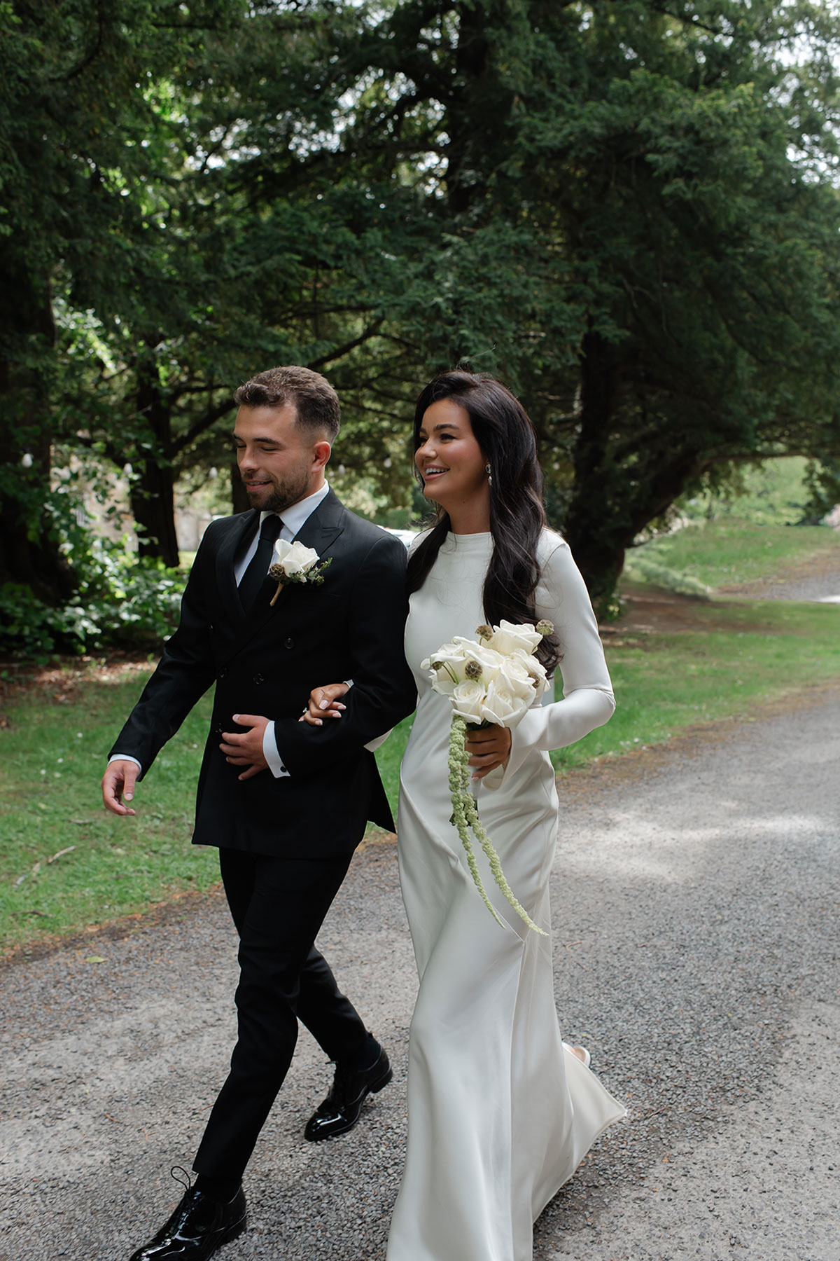 Bride and groom walking along path at Carberry Tower 