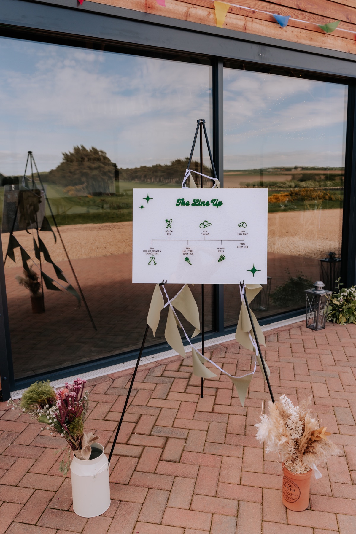 Wedding day timeline sign displayed outside Harvest Moon for Hannah and Donna’s celebration.