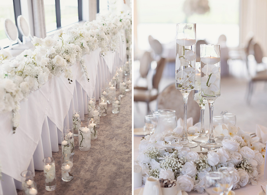 a long table set for a wedding with lush white flower garland running along the front of it with floating candles in glass vases on floor in front of it (left). Champagne flutes filled with white orchids and small tea lights surrounded by white flowers on a table on right 