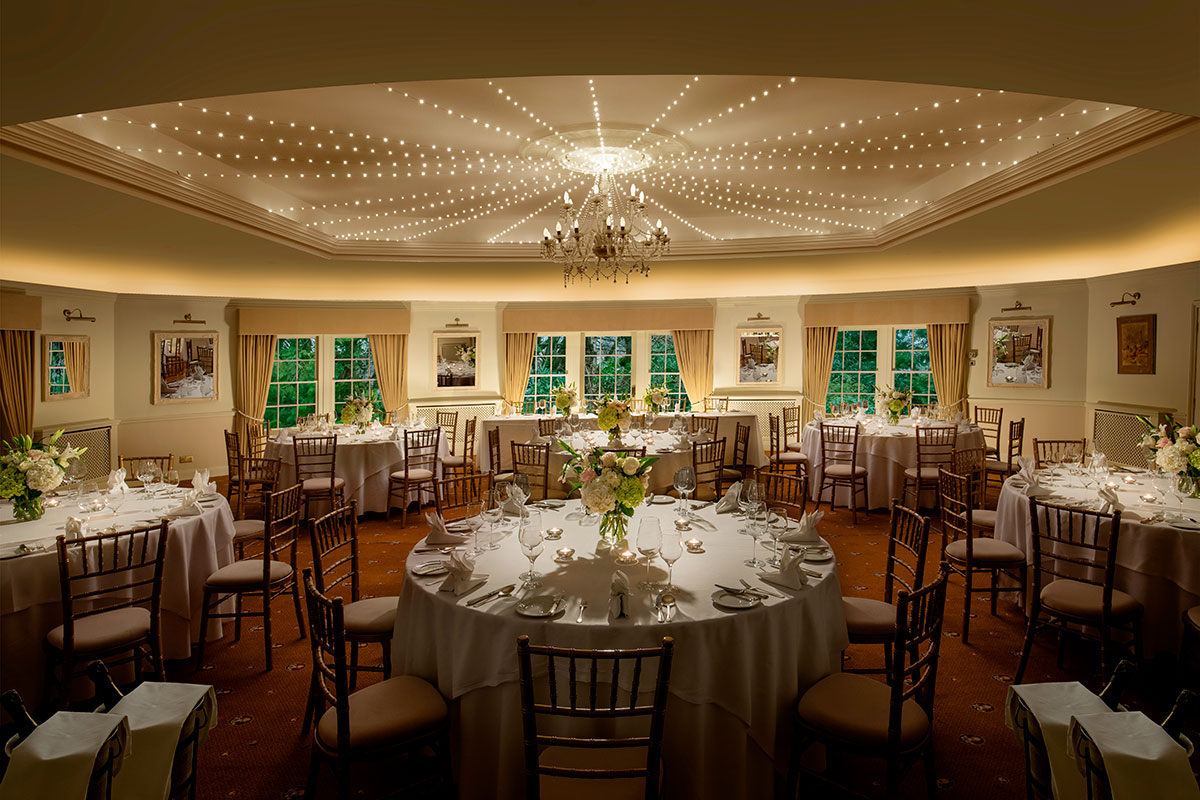 Thackray House wedding reception room set for dinner with round tables, floral centrepieces and fairy lights.