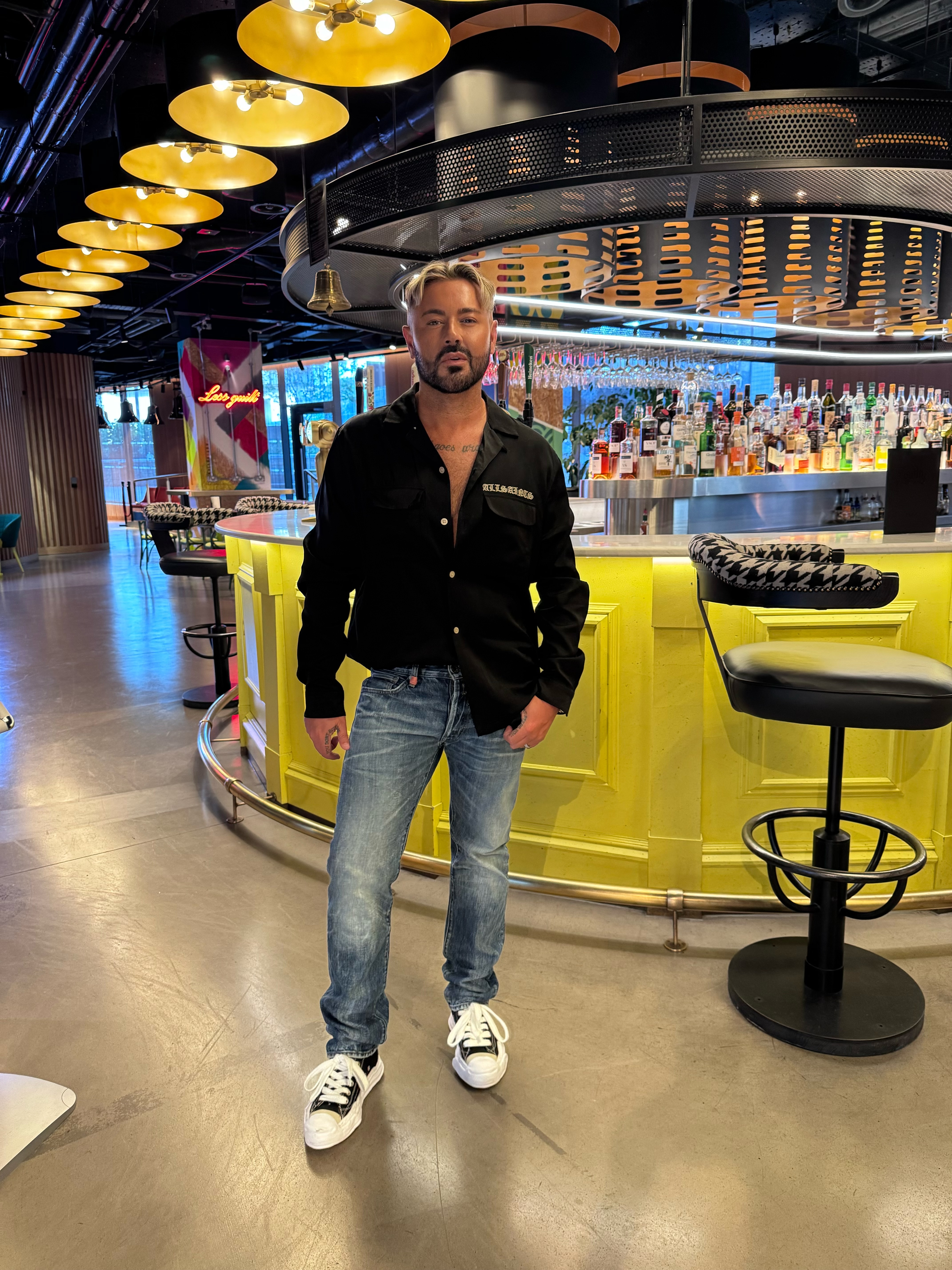 full length picture of influencer dean rowland wearing black shirt and blue jeans