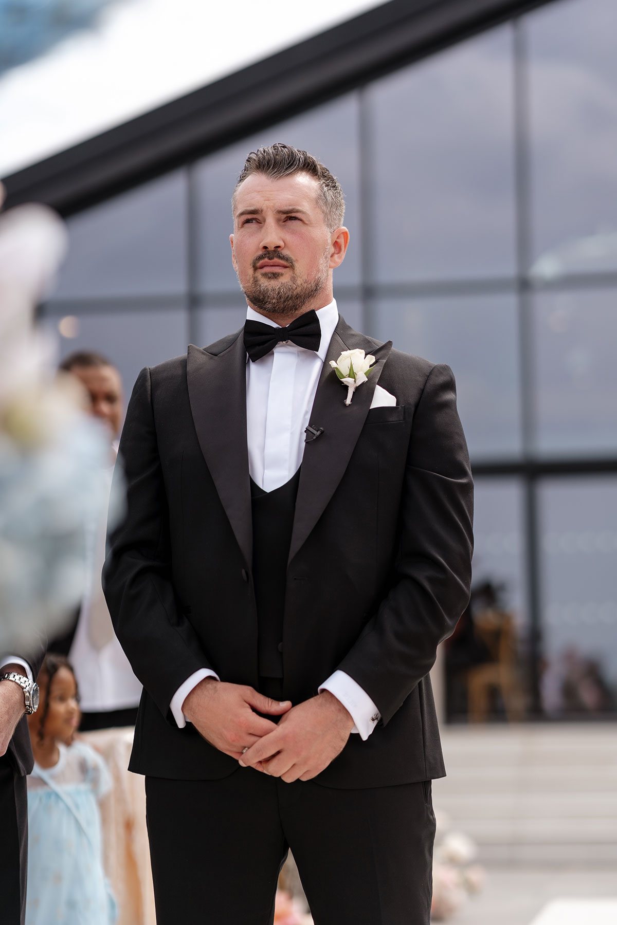 Groom waits for the bride during the outdoor wedding ceremony at Boturich Castle overlooking Loch Lomond.