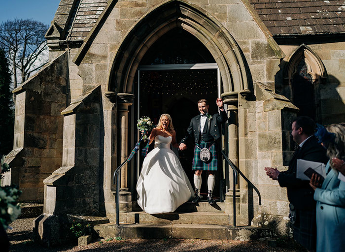 a bride and groom exiting a church