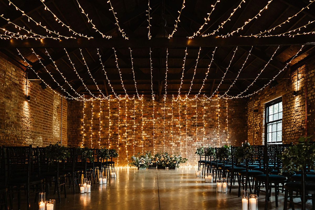 Ceremony setup at The Engine Works with candles, chairs and fairy lights