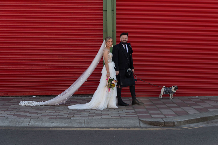 Bride and groom walking pug in Glasgow Barras