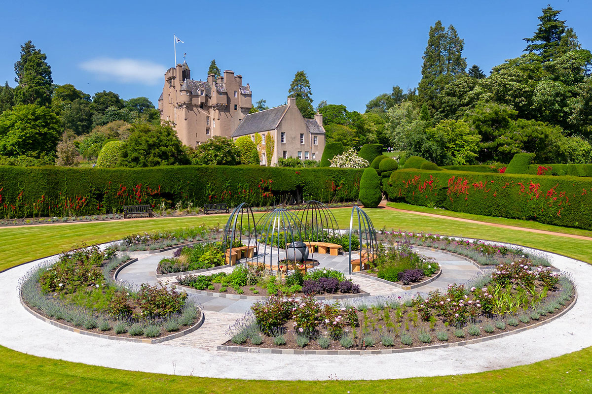 Circular rose garden and landscaped grounds at Crathes Castle with the historic Scottish castle in the background