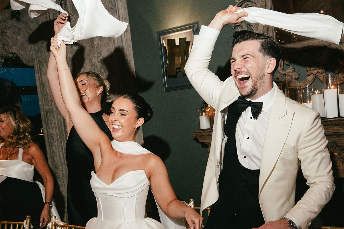 Wedding day rave moment with bride and groom waving napkins during reception at Enterkine Country House Ayrshire